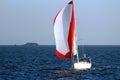 Sloop sailboat on a quiet sea in open waters. Royalty Free Stock Photo