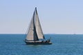 Sloop sailboat on a quiet sea in open waters. Royalty Free Stock Photo