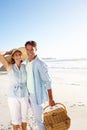 Perfect day for a picnic. Portrait of a happy couple going for a picnic on the beach together. Royalty Free Stock Photo