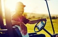 The perfect day to be on the fairway. Portrait of a happy young man driving a cart on a golf course. Royalty Free Stock Photo