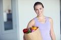 The perfect diet consists of healthy fresh foods. Portrait of a young attractive woman carrying a bag of groceries at Royalty Free Stock Photo