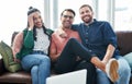 The perfect ensemble for a progressive startup. Portrait of two young men and a woman relaxing together on a sofa. Royalty Free Stock Photo