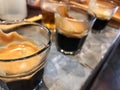 3 perfect espresso shots in glass on the cement counter.