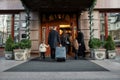 Perfect family getaway. Full-length shot of family of tourists, father, mother, daughter and son with a grey suitcase