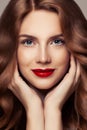 Perfect female face closeup portrait. Pretty woman with curly shiny hair and red lips makeup Royalty Free Stock Photo