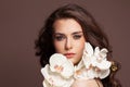 Perfect female face with healthy clear skin and white orchid flowers portrait. Facial treatment and skin care concept Royalty Free Stock Photo