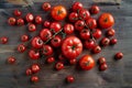 Perfect fresh different sort red tomatoes on a branch at wooden background from above.