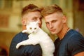 Perfect furry friend. Cat is a part of their family. Muscular men with cute cat. Happy cat owners on walk with pet