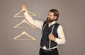 perfect look. formal stylish mens clothing on hanger stand in room. tailor man holds in his hand a hanger. Handsome man