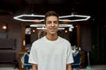 Perfect look. Portrait of happy young guy in white T-shirt looking at camera and smiling while visiting modern Royalty Free Stock Photo