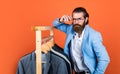 Perfect male. Large selection of mens suits. bearded man choose jacket on hanger. male wardrobe concept. man go shopping