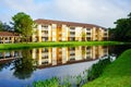 Perfect mirror reflection: Yellow condos or apartments and a small pond