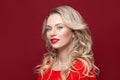 Perfect model blonde woman smiling and looking at camera on red background Royalty Free Stock Photo