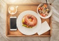 The perfect mothers day gift. A tray of a well balanced breakfast, a bagel, coffee and a cellphone. Everything needed Royalty Free Stock Photo