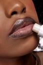 Perfect natural lip makeup. Close up photo of African-American woman applying hygienic lip balm. Moisturizing chap stick Royalty Free Stock Photo