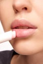 Perfect natural lip makeup. Close up photo of woman applying hygienic lip balm. Moisturizing chap stick for dry lips. Royalty Free Stock Photo