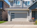 Garage door with driveway. Big modern custom house front yard and driveway to garage on a sunny summer day Royalty Free Stock Photo