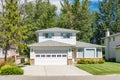 A perfect neighbourhood. Family house with landscaped front yard and concrete driveway. Residential house with wide garage on Royalty Free Stock Photo