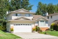 A perfect neighbourhood. Family house with landscaped front yard and concrete driveway on sunny day in British Columbia Royalty Free Stock Photo