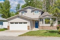 A perfect neighbourhood. Family house with landscaped front yard and concrete driveway. Residential house with wide garage on Royalty Free Stock Photo