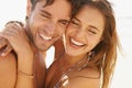 The perfect picture of young love. Ay beautiful young couple embracing and laughing together on the beach. Royalty Free Stock Photo