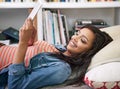 The perfect place for a bit of surfing. a young woman using her digital tablet at home.