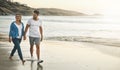 This is the perfect place to express your love. a loving couple walking hand in hand on the beach. Royalty Free Stock Photo