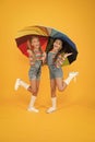 Perfect place to stay. small girl under colorful umbrella. two happy kids yellow background. children enjoy rainy autumn Royalty Free Stock Photo