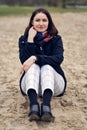 The smiling girl is sitting on the sand. Royalty Free Stock Photo