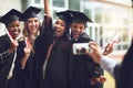 The perfect pose for the last picture. fellow students taking a picture together on graduation day.