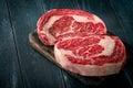 Perfect raw rib eye beef steak on black wooden Royalty Free Stock Photo