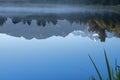 Perfect reflection in Lake Matheson surrounded by beautiful natural forest under blue sky Royalty Free Stock Photo