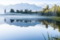 Perfect reflection in Lake Matheson surrounded by beautiful natural forest under blue sky Royalty Free Stock Photo