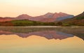 Perfect reflection of mountains glowing with the sunrise in a lake