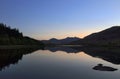 Perfect reflection of mountains reflected in a glassy lake at sunset