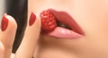 Perfect sexy female lips. Close up female lips with raspberry. Female hand with red nail design holding raspberry