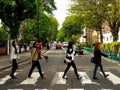 Perfect shot of four the beatles fans walking across the so famous Abbey Road Zebra Crossing