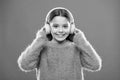 Perfect sound stereo headphones. Girl cute little child wear headphones listen music. Kid listen music orange background