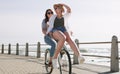 The perfect summer date. Full length shot of a happy young couple riding a bicycle together on a promenade near the Royalty Free Stock Photo