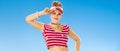 Portrait of smiling young woman in red sun visor on seacoast Royalty Free Stock Photo