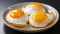 Perfect sunny side up eggs on a plate, with bright yolks and crispy edges