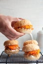 Buns with chicken, carrot and sour cream sauce in a man`s hand