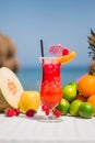 Perfect tropical cocktail with a paper parasol and fresh fruits on a beach Royalty Free Stock Photo