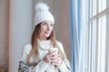 Perfect winter woman holding hot dring and resting at home, romantic portrait