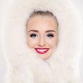 Perfect winter woman portrait. Beautiful female model face with fresh clear skin, makeup and cute smile in white fur Royalty Free Stock Photo