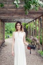 Perfect young woman fashion model in white dress with bird outdoors in park Royalty Free Stock Photo