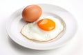 Perfectly cooked fried egg with a runny yolk on a white plate, isolated on a white background