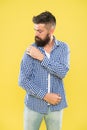 Perfectly imperfect. Fashion man dusting specks off his sleeve on yellow background. Bearded man in hipster fashion