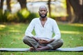 Perfectly peaceful. Full length shot of a handsome young man meditating while practicing yoga outside at the park.