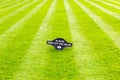 Perfectly striped freshly mowed garden lawn with a warning sign